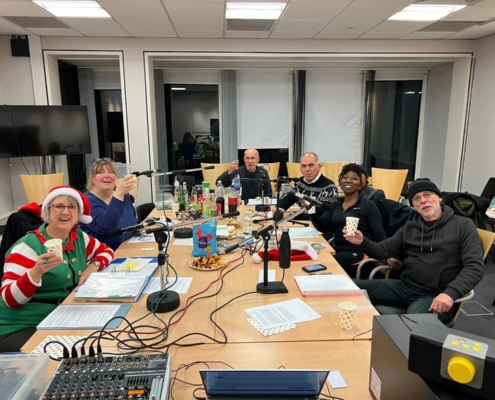 Bambos Charalambous MP pictured with the Enfield Talking Newspaper team during the festive edition recording